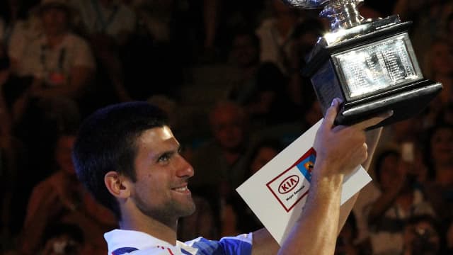 Novak Djokovic ergue um troféu durante cerimônia de premiação em quadra de tênis