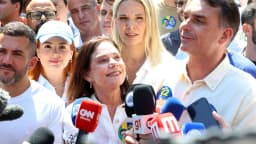 O senador Flávio Bolsonaro cercado de microfones de emissoras de TV durante entrevista coletiva à imprensa