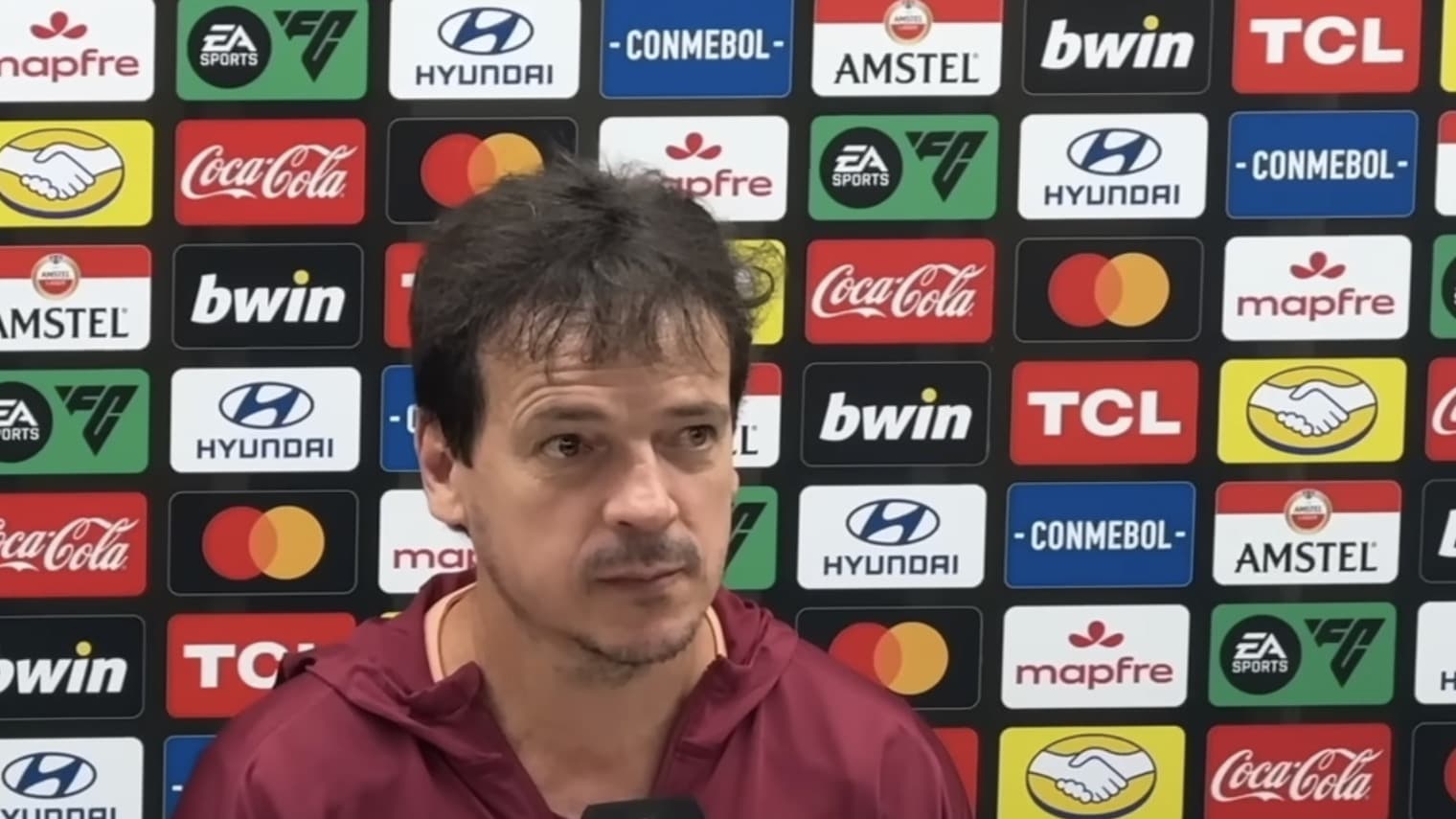 Técnico Fernando Diniz em coletiva de imprensa vestindo agasalho do Corinthians