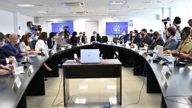 Autoridades reunidas em mesa oval durante encontro sobre segurança pública em Pernambuco