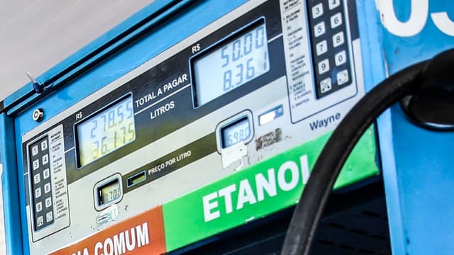 Bomba de combustível em posto, com os mostradores de preço e as faixas indicando gasolina comum e etanol