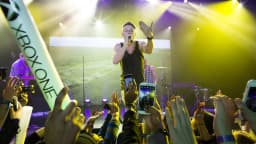 Macklemore se apresenta em show, segurando microfone