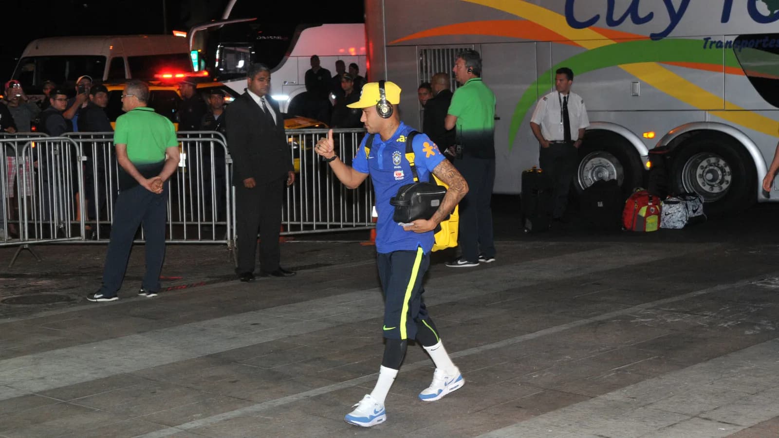 Jogador da Seleção Brasileira caminha com equipamento de viagem em desembarque