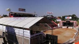 Arena de rodeio vista de cima, com arquibancadas e telão ao fundo