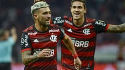 Dois jogadores do Flamengo em uniforme vermelho e preto comemorando gol em jogo anterior do clube