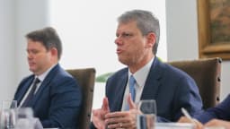 Tarcísio de Freitas fala em reunião de trabalho, vestindo terno azul-marinho