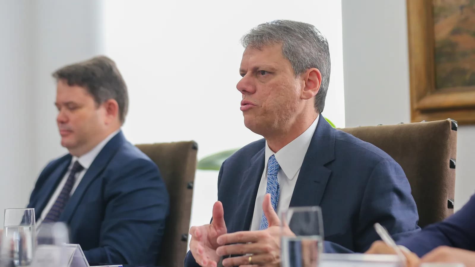 Tarcísio de Freitas fala em reunião de trabalho, vestindo terno azul-marinho