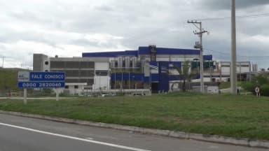 Fachada de uma fábrica da Nestlé no Brasil, com o logo da marca visível na entrada do complexo industrial