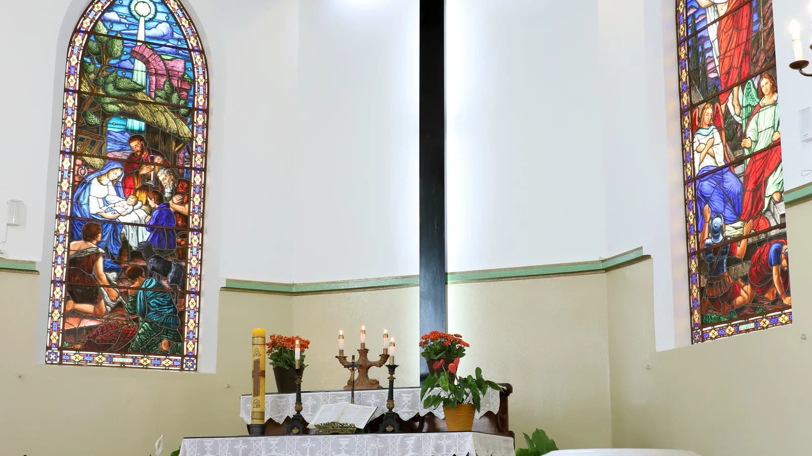 Interior de igreja evangélica luterana, com cruz iluminada e vitrais, foto ilustrativa de templo religioso