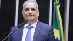 Alfredo Gaspar discursa ao microfone em sessão da Câmara dos Deputados, com a bandeira do Brasil ao fundo