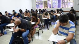 Candidatos adultos fazendo prova em sala de aula