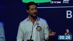 Gabriel Azevedo, candidato ao governo de Minas Gerais com o número 15, fala ao microfone em púlpito do debate, com cronômetro de 30 segundos na tela