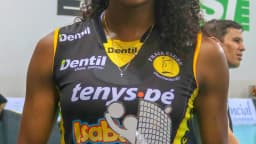 Jogadora do Praia Clube sorri segurando troféu de melhor em quadra do vôlei feminino