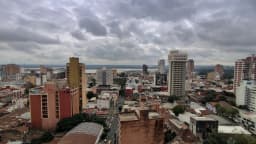 Vista aérea do centro de Assunção, capital do Paraguai, com prédios e o rio ao fundo