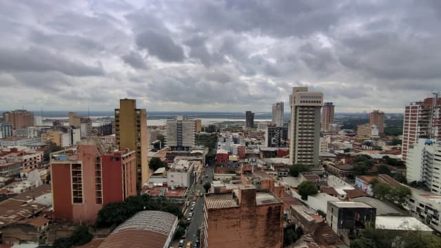 Vista aérea do centro de Assunção, capital do Paraguai, com prédios e o rio ao fundo