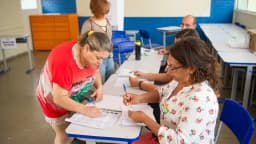 Mesários auxiliam eleitores em seção de votação