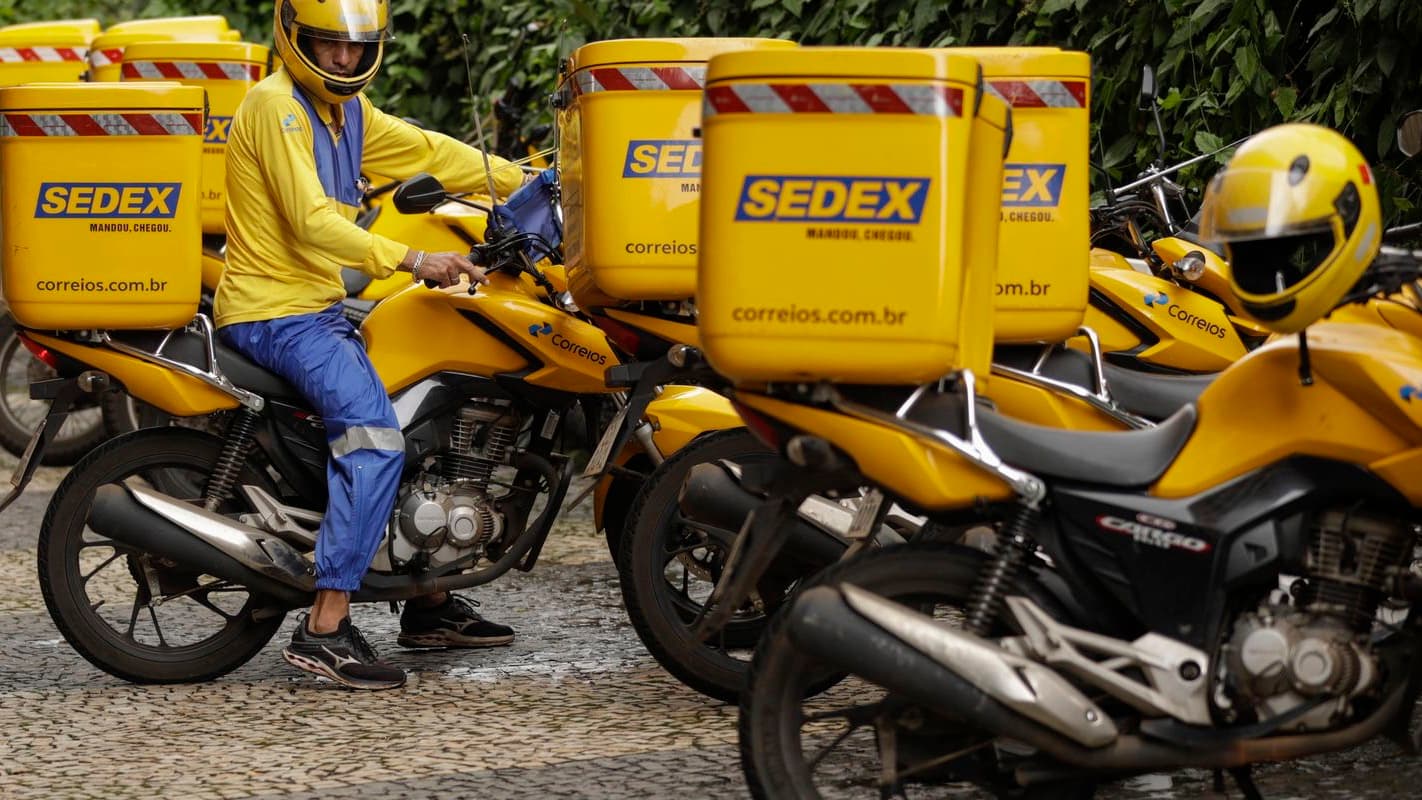 Carteiro dos Correios sobre motocicleta com baús do Sedex, foto de arquivo ilustrativa de encomendas