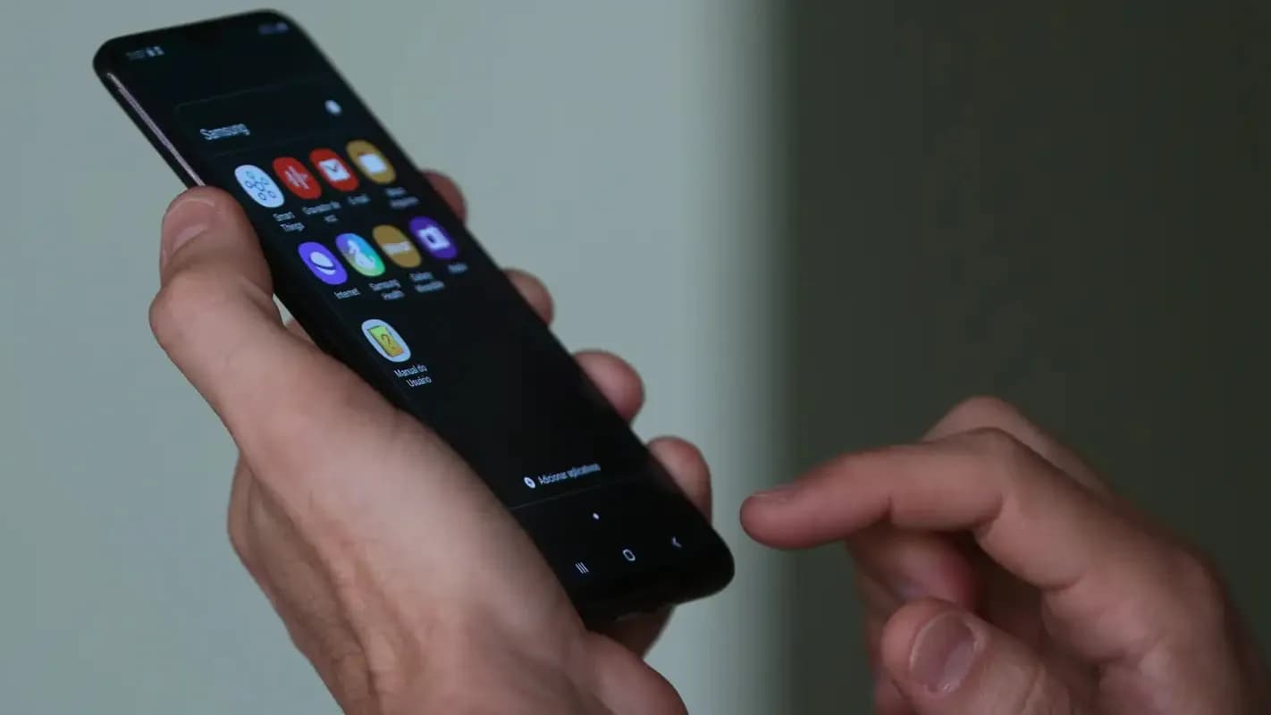 Pessoa segura um smartphone com as duas mãos