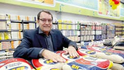 Pedro Lourenço em loja do Supermercados BH, cercado por sacas de arroz