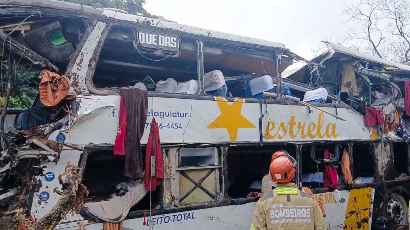 Ônibus destruído após tombar na BR-040, em Petrópolis, com bombeiro do Corpo de Bombeiros do Rio em primeiro plano