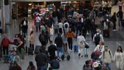 Passageiros com malas caminham pelo saguão do Aeroporto de Guarulhos em dia de grande movimento