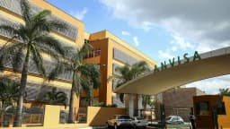 Fachada da sede da Anvisa em Brasília, com palmeiras e o letreiro verde da agência na entrada