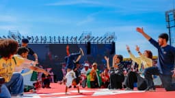 Público em ato de campanha de Lula, com performance no palco durante evento
