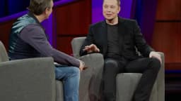 Elon Musk sentado em entrevista durante evento