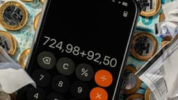 Calculadora no celular sobre dinheiro em espécie e recibos