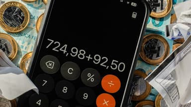 Calculadora no celular sobre dinheiro em espécie e recibos