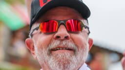 O presidente Luiz Inácio Lula da Silva sorri durante caminhada de campanha, cercado por apoiadores