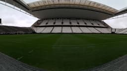 Vista interna da Neo Química Arena, estádio do Corinthians, com o gramado e a arquibancada ao fundo