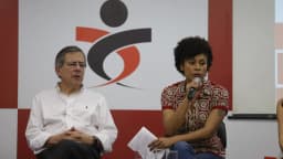 Painel de debate sindical com dois participantes, um deles falando ao microfone, em evento sobre a categoria bancária (foto de arquivo)