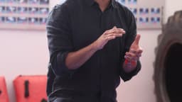 Professor de braços cruzados em sala de reunião (foto de arquivo, contexto de atividade docente)