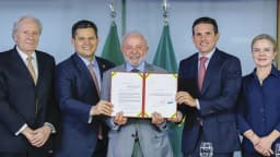 O presidente Lula ao lado de autoridades segurando o documento da PEC da Segurança Pública em cerimônia no Palácio do Planalto