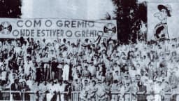 Torcida do Grêmio reunida em 1946 segurando faixa com os dizeres 'Com o Grêmio onde estiver o Grêmio', foto histórica de arquivo
