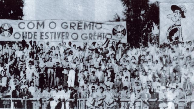 Torcida do Grêmio reunida em 1946 segurando faixa com os dizeres 'Com o Grêmio onde estiver o Grêmio', foto histórica de arquivo