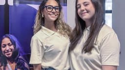 Duas jovens pesquisadoras sorridentes em ambiente universitário (foto ilustrativa)