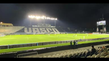 Estádio de São Januário à noite durante partida do Vasco, com o nome do clube nas arquibancadas
