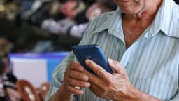 Homem segura celular ao acessar site de apostas esportivas