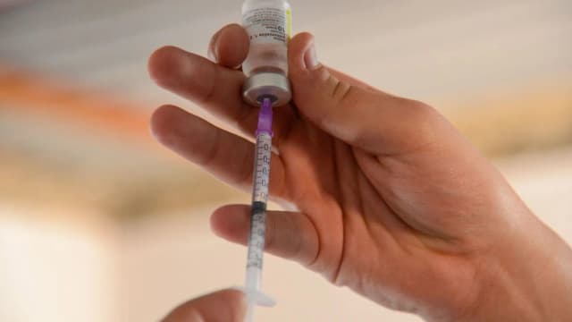 Mão de profissional de saúde prepara seringa com frasco de vacina (foto ilustrativa, sem relação direta com o caso relatado)