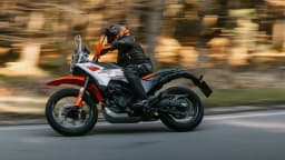 Motociclista pilota a KTM 390 Adventure X em estrada, foto de divulgação