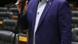 Domingos Sávio discursa ao microfone no plenário da Câmara dos Deputados, de terno azul-marinho
