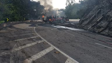 Imagem de arquivo mostra veículos em chamas interditando pista da BR-040 após outro acidente, com fumaça densa subindo entre a vegetação