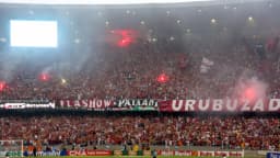 Torcida do Flamengo lotando a arquibancada do Maracanã com fumaça e sinalizadores, faixa Urubuzada estendida