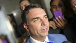 Senador Flávio Bolsonaro concede entrevista a jornalistas cercado de microfones