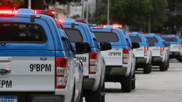 Viaturas da Polícia Militar do Rio enfileiradas em via pública, com giroflex acionado, durante operação no Complexo da Maré
