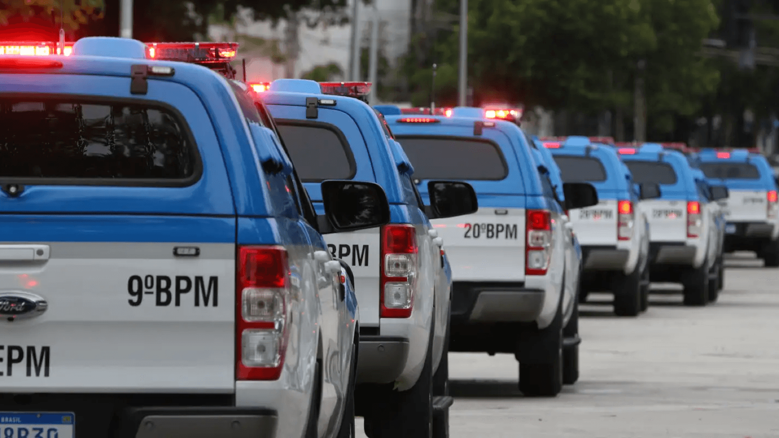 Viaturas da Polícia Militar do Rio enfileiradas em via pública, com giroflex acionado, durante operação no Complexo da Maré