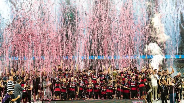 Jogadores do Flamengo celebram título com fogos de artifício e confete no gramado, foto de arquivo de comemoração do clube