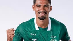 Kadu Sousa, atacante do Goiás, posa sorrindo com o uniforme verde do clube em foto oficial